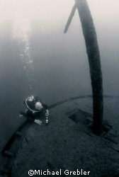 A diver checks his gauges at the stern of the Rothesay wh... by Michael Grebler 